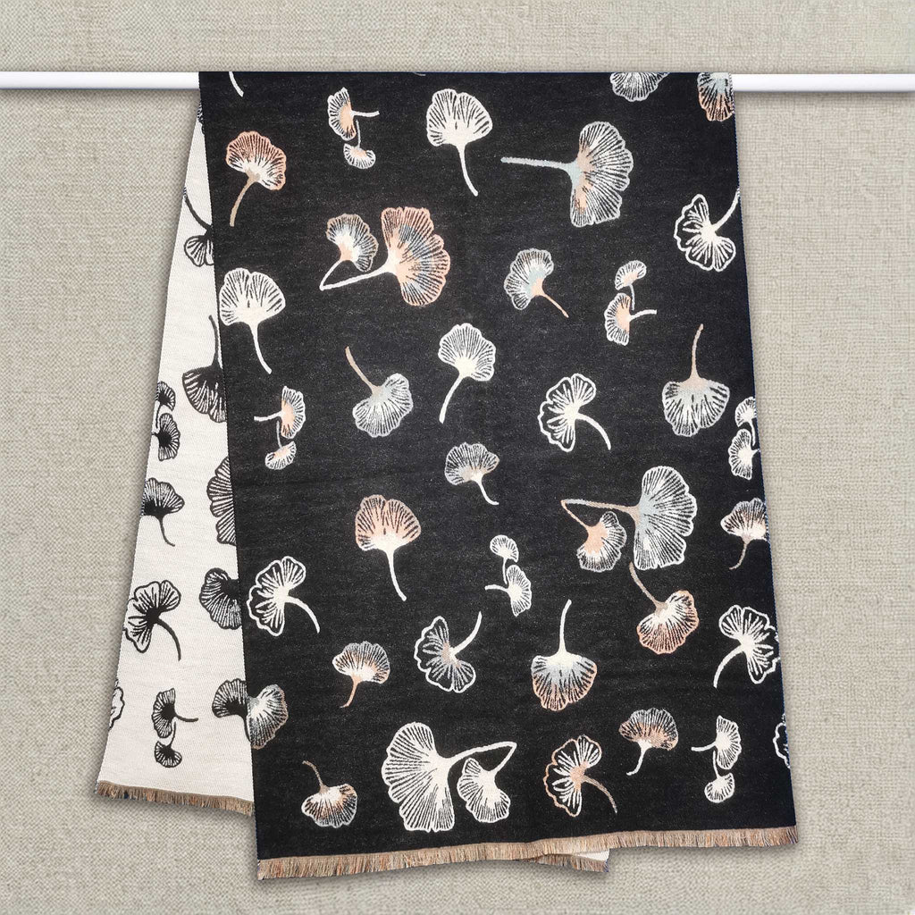 A black women scarf with ginkgo leaf pattern is hanging on clothing rack, The cashmere-feel fabric is very soft, warm and with high-quality workmanship. This fashion scarf is reversible and large size, approx. width 65 cm, length 180 cm and weight 330g