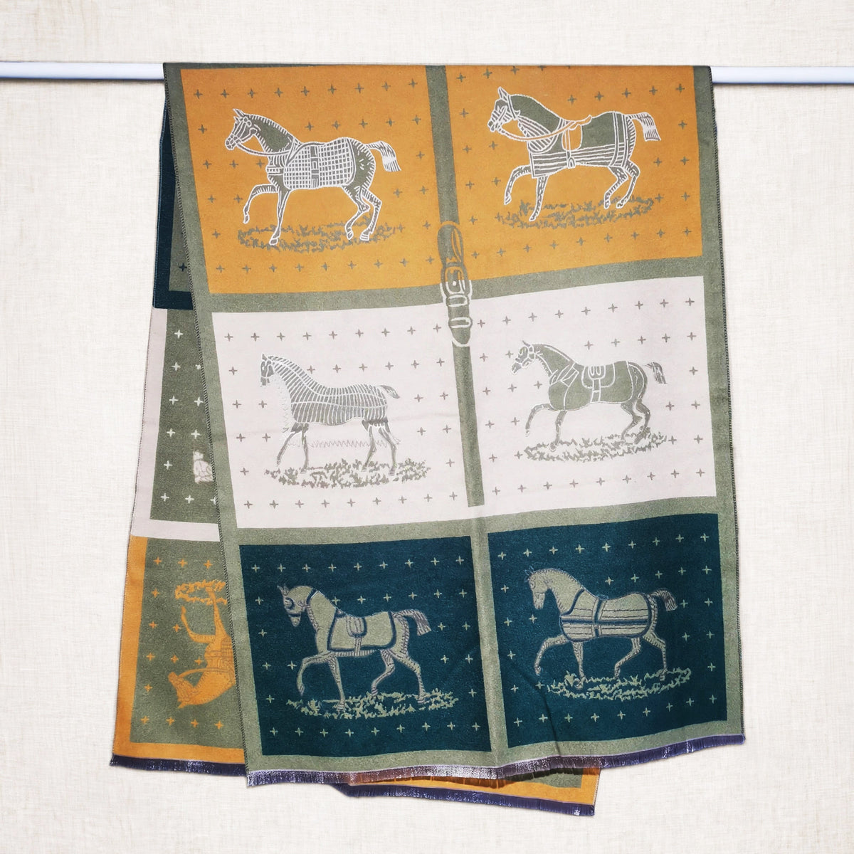 cashmere-feel olive-green winter scarf with mustard yellow and teal panel and horse print. The unisex scarf hanging on rod. Large size, approx. width 65 cm, length 180 cm and weight 330g