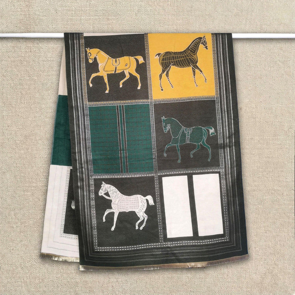 Dark green cashmere-feel winter scarf with yellow and cream panels and horse pattern hanging on clothing rack