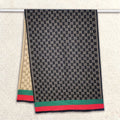 Full view of a double-sided black women scarf with monogram classic pattern is hanging on rod. The fashion winter scarf is crafted from cashmere-feel fabric that is soft, warm and high-quality. Reversible and large size, approx. width 65 cm, length 180 cm and weight 330g