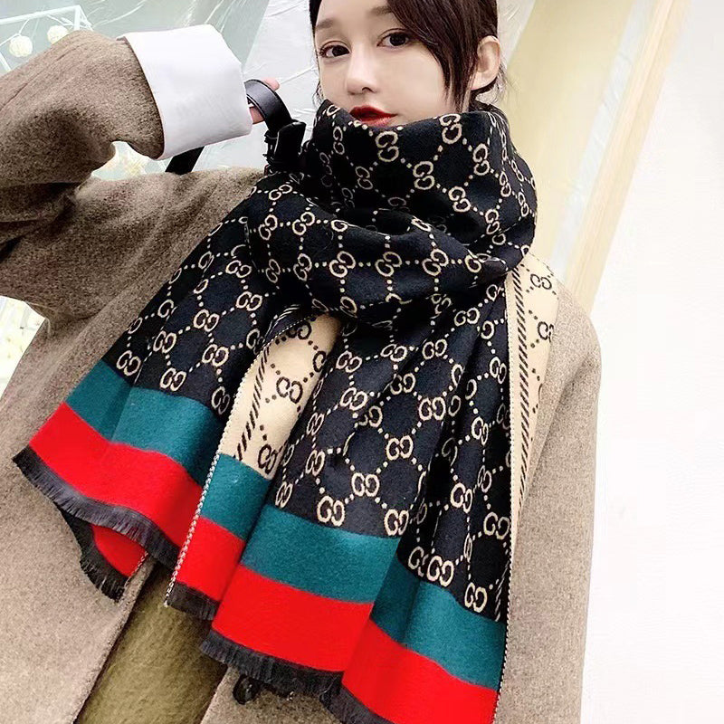 Woman wearing wrapped black winter scarf with monogram pattern and red green stripes. This winter scarf is crafted from cashmere-feel fabric that is very soft, warm and high-quality. Reversible and large size, approx. width 65 cm, length 180 cm and weight 330g