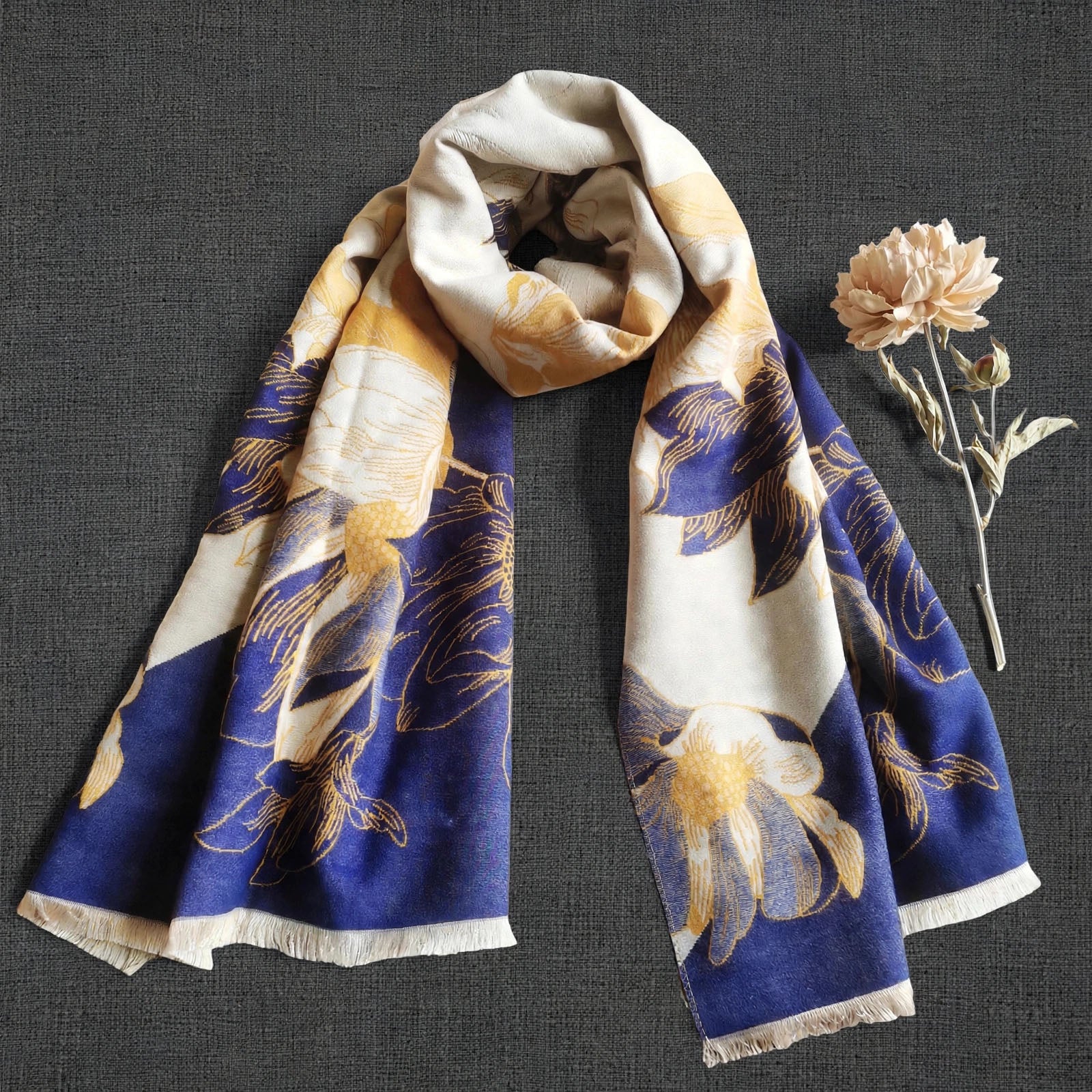 Winter women scarf in navy and yellow floral pattern displayed with dried flower, It is a large size scarf and reversible. Cashmere-feel fabric and the clear pattern crafted with high-end workmanship.