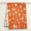 An orange women scarf with floral pattern is hanging on clothing rack. It is a large size scarf. The cashmere-feel fabric is very soft, warm and with high-quality workmanship.