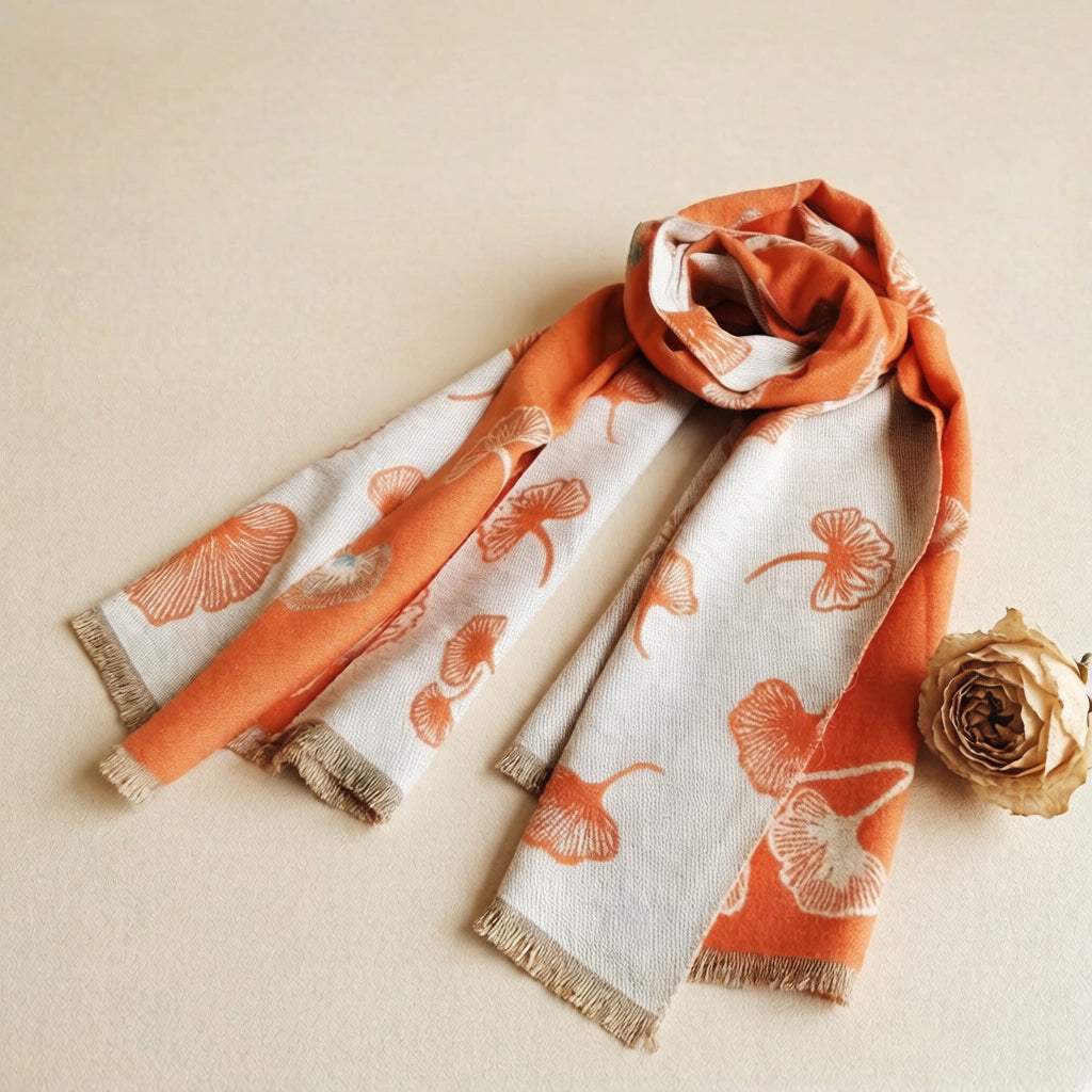 Orange cashmere-feel large size women scarf styled with a dried flower. This winter scarf is reversible, one side orange, another side cream. The clear floral pattern showing the winter shawl is crafted in high-end workmanship