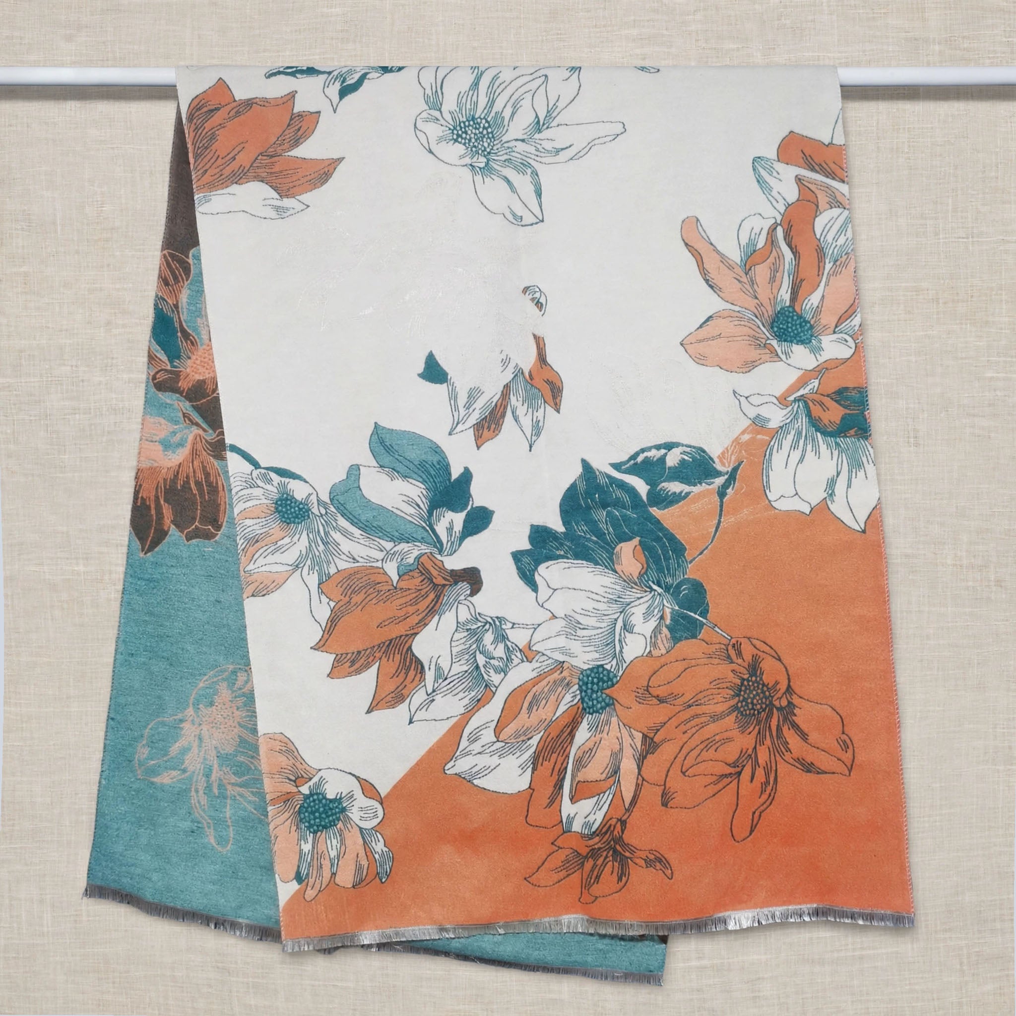 cashmere-feel winter women scarf draped open showing ivory background with orange and teal flowers. The clear pattern crafted with high-end workmanship.
