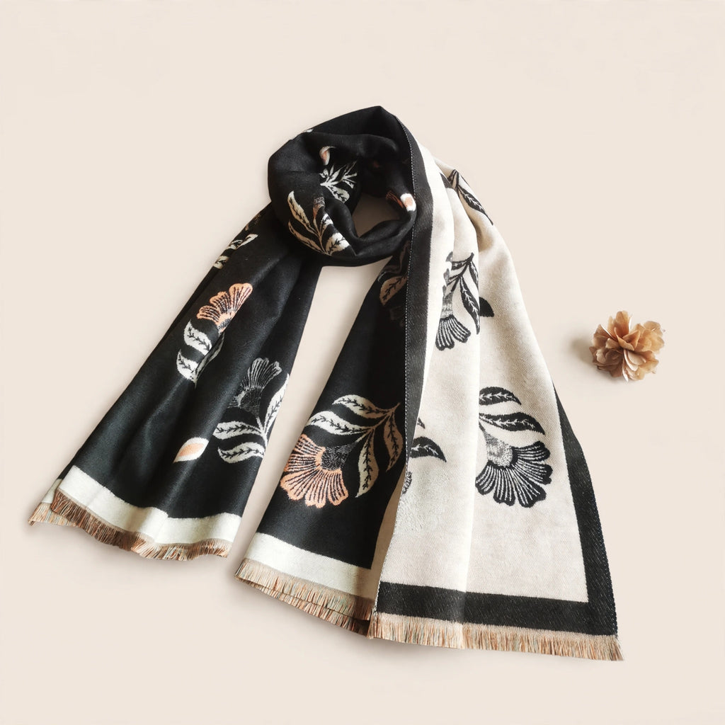 Floral black women winter scarf cashmere-feel fabric laid flat on beige background showing black side with coral flowers
