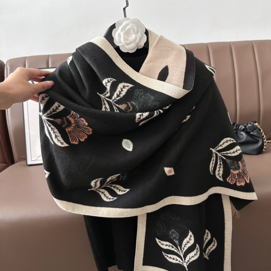 Black floral black cashmere-feel shawl draped over shoulders showing large size wrap styling with cream border and coral flower accents