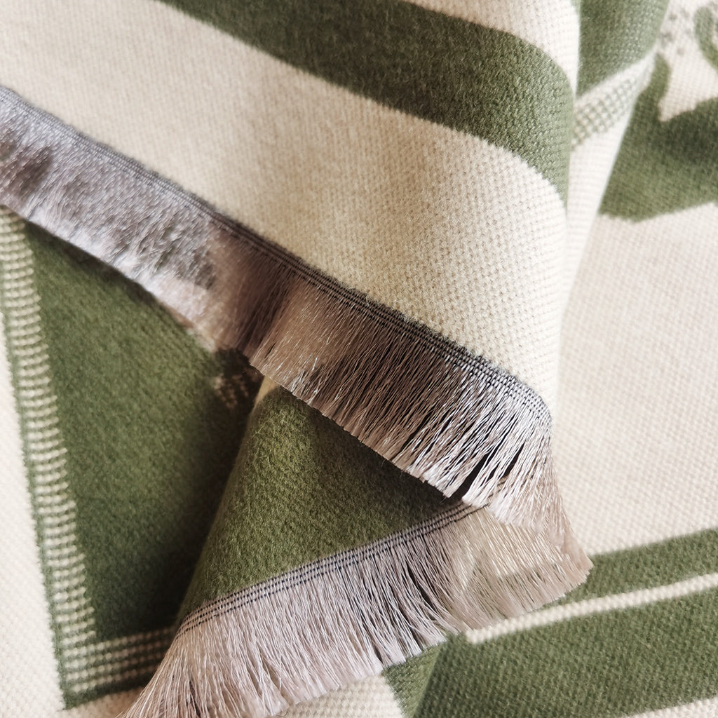 Close-up detail of the fringe of an olive-green cashmere-feel men scarf. The fabric detail shows the neck scarf is very soft and warm, and crafted from high-quality workmanship