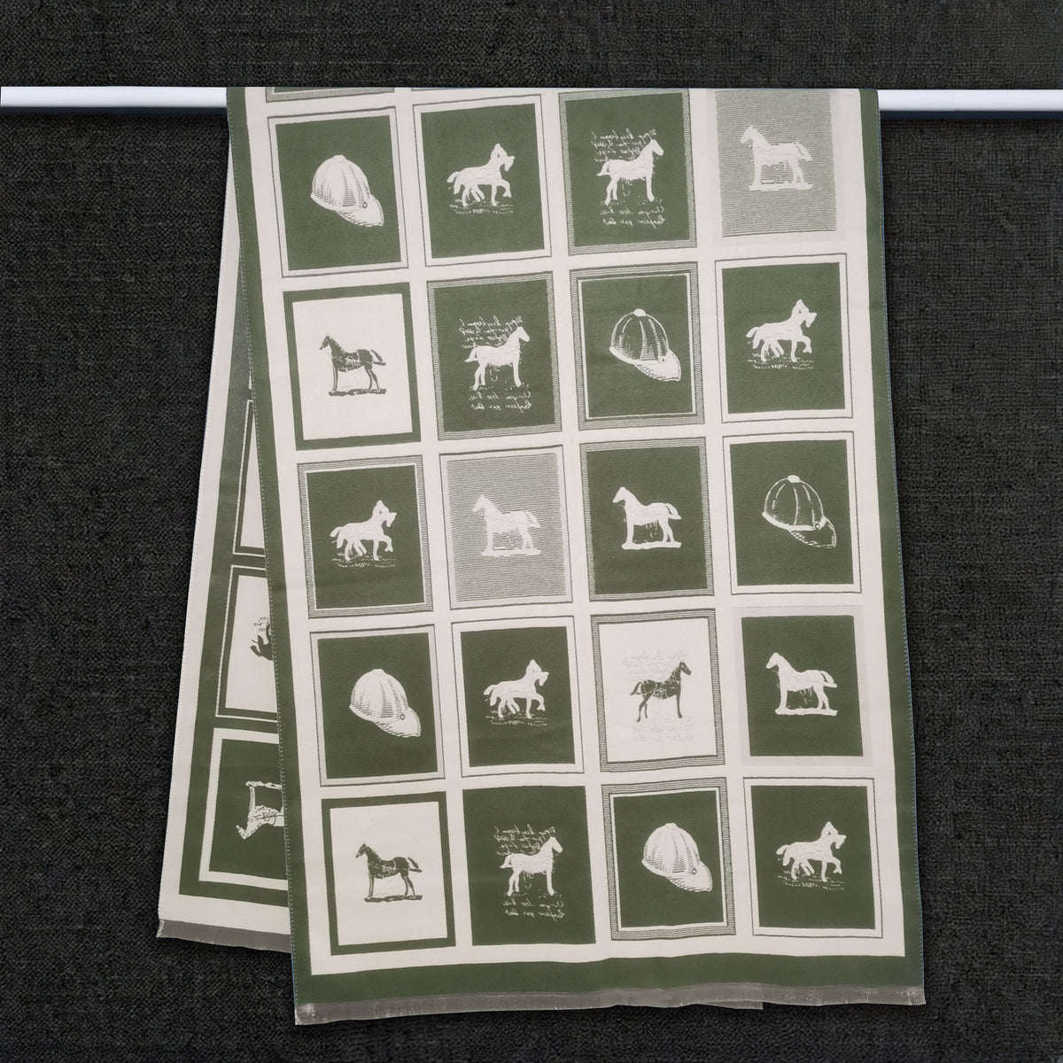 Olive green winter men scarf with horse pattern in color block is hanging on clothing rack, This large size neck scarf is reversible and crafted from cashmere-feel fabric