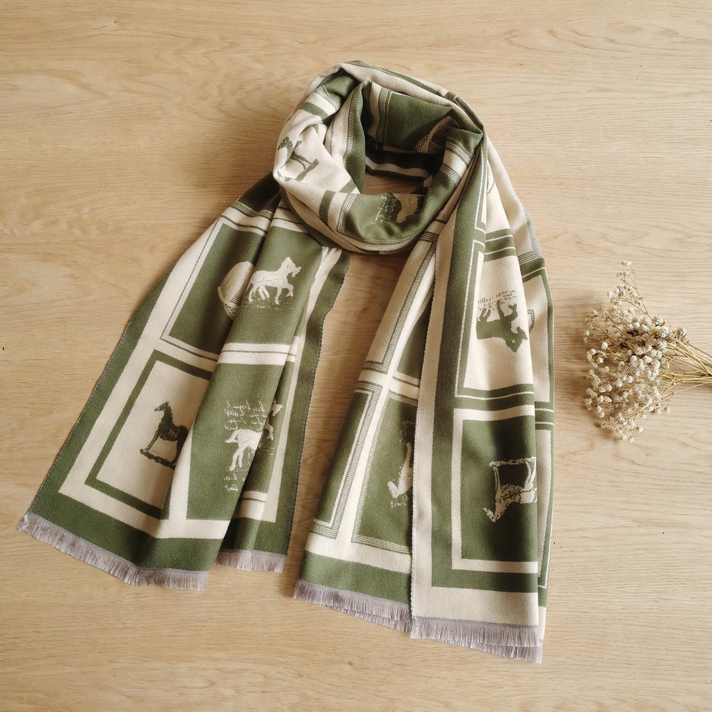Olive green cashmere-feel large size men scarf styled on light table with a dried flower. This winter scarf is reversible. The clear horse pattern showing the winter men’s neck scarf is very soft, warm and crafted from high-end workmanship
