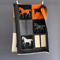jacquard winter women scarf with equestrian horse print in black white and orange color block design laid flat showing full pattern fringe edges