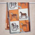 Luxury style orange ivory equestrian print panel cashmere-feel shawl displayed on hanger rack. A warm piece for winter