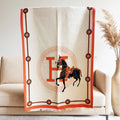 Full view of large scarf ivory color with black equestrian horse and orange border and letter print