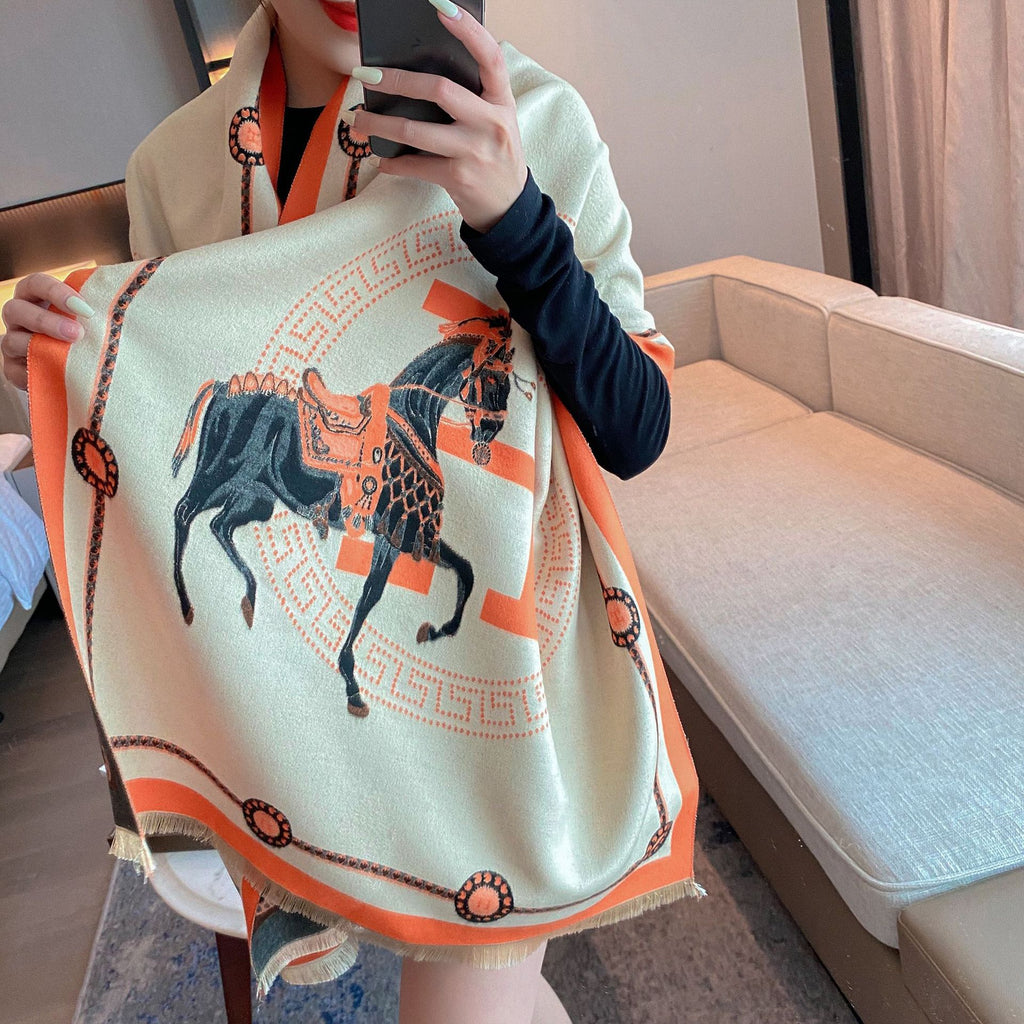 Woman wrapping large ivory scarf featuring black horse and orange letter and border