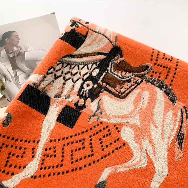 Close-up of orange scarf fabric showing horse pattern and black pattern