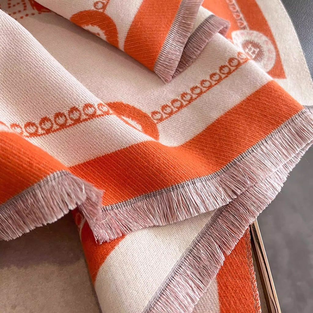 Close-up of ivory luxury equestrian print cashmere-feel winter scarf with fringe trim and orange border details